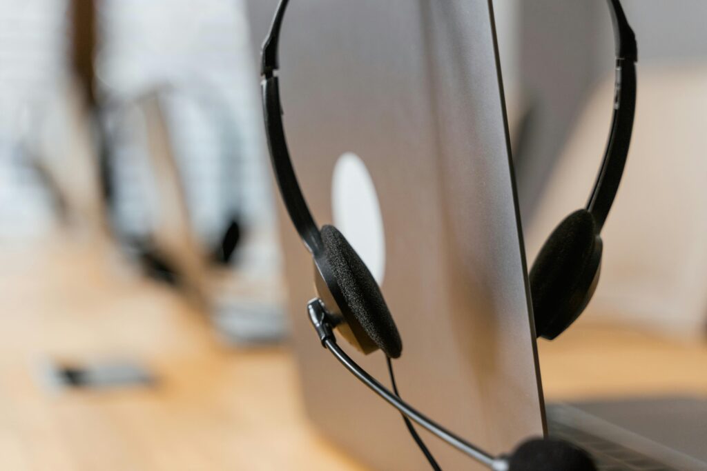 pexels-photo-7709176-7709176 Close-up of a headset resting on a laptop, symbolizing efficient work environment technology.